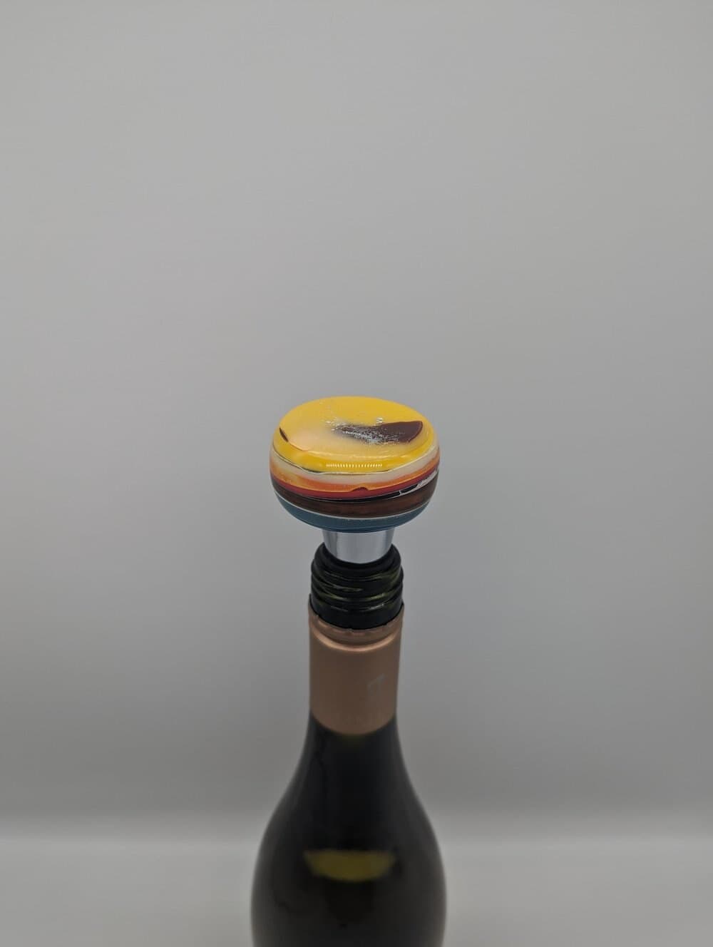 Wine bottle fitted with a colourful upcycled resin stopper.