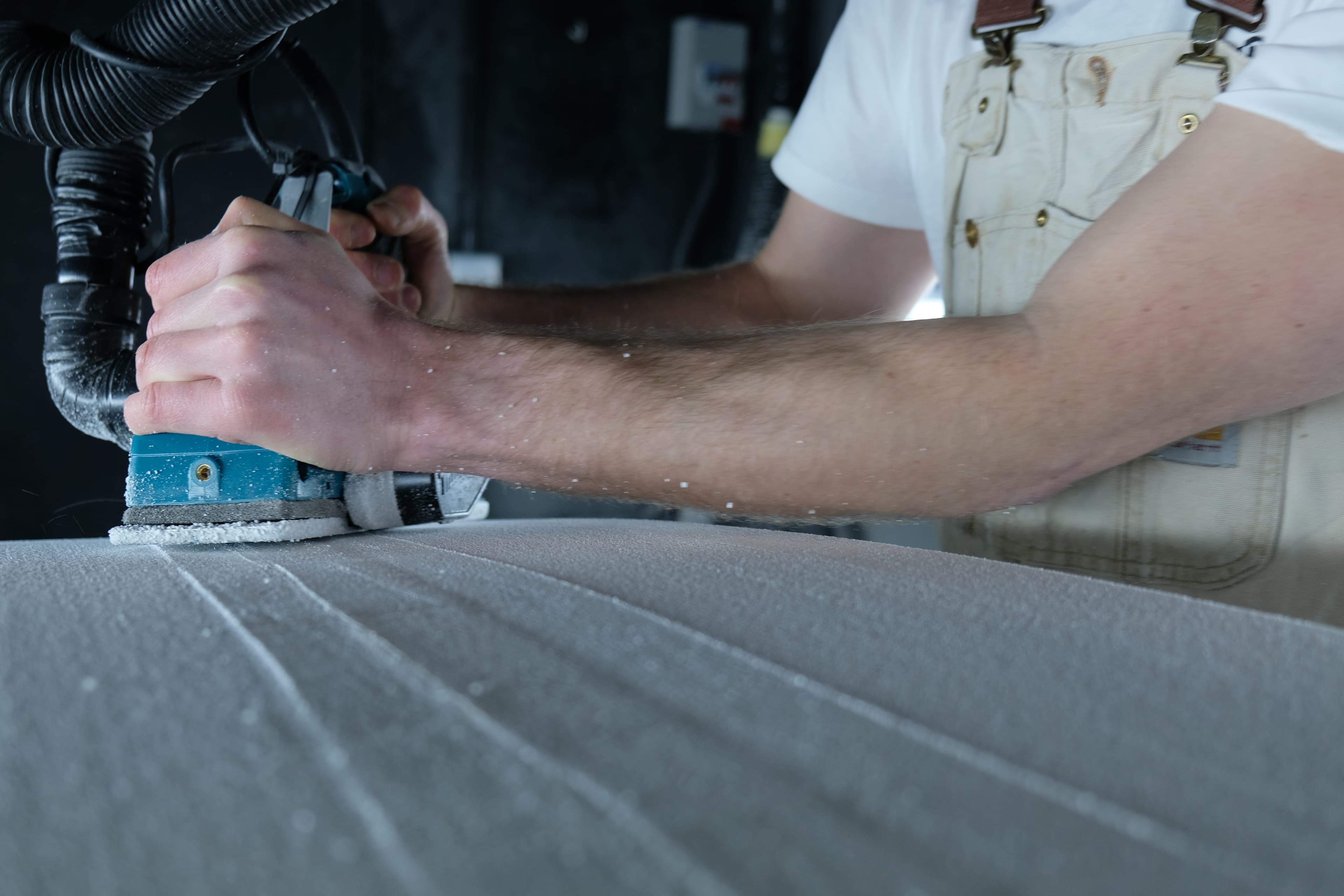 A board being sanded during repair work in the Whitburn Studio workshop.