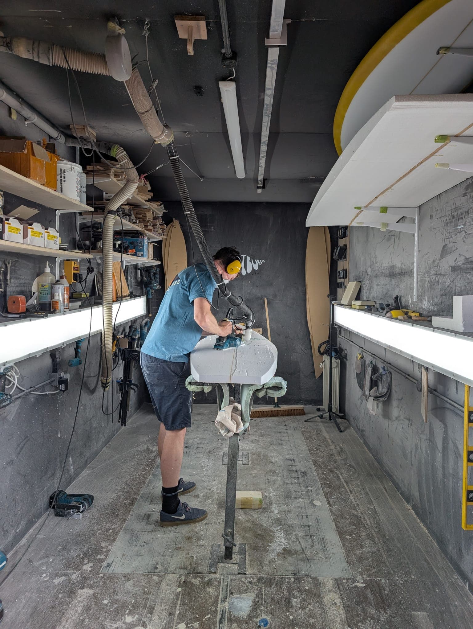 A surfboard being shaped inside the Whitburn Studio workshop.