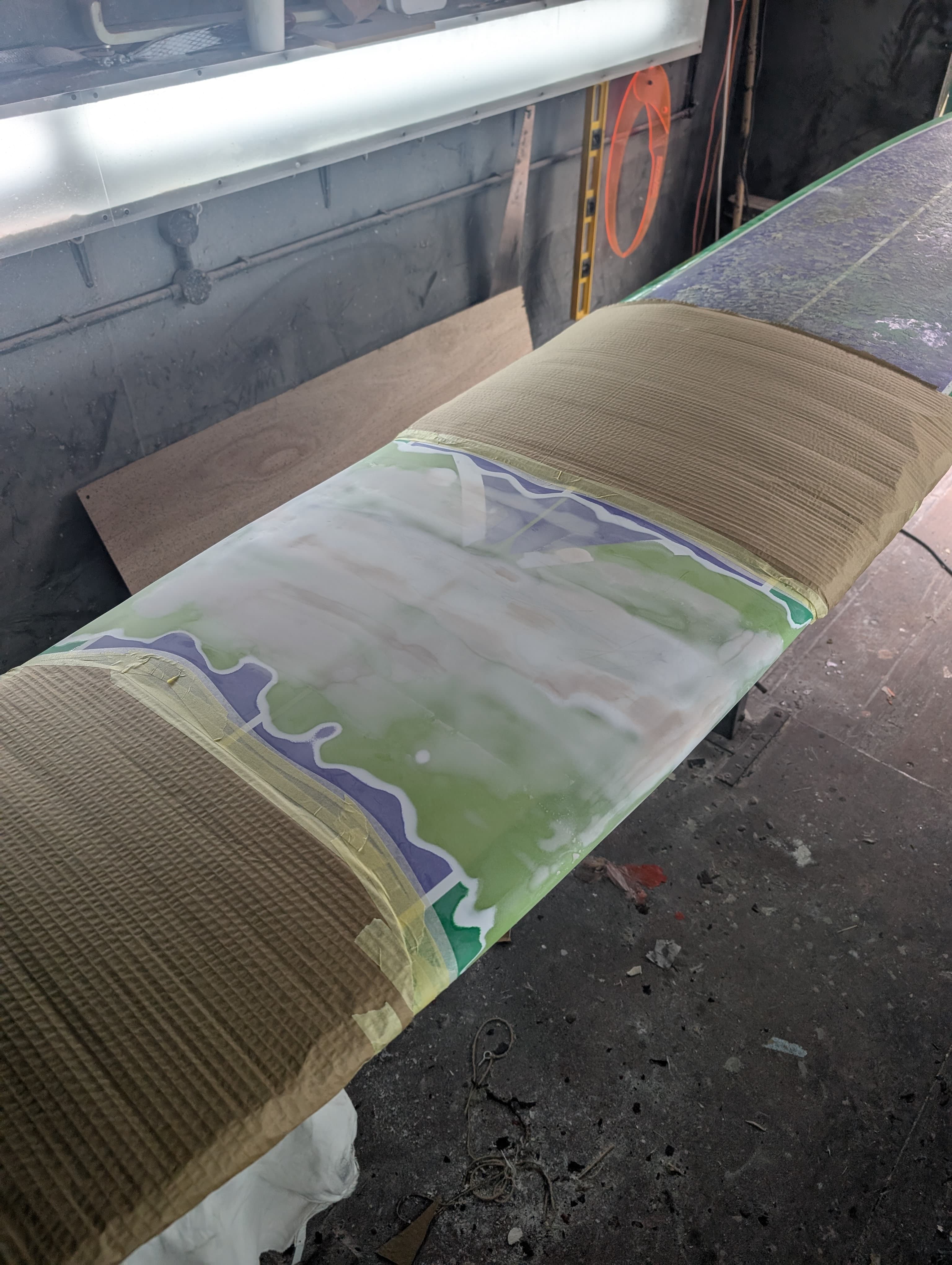 The snapped surfboard after repair with fresh glass and colour work.